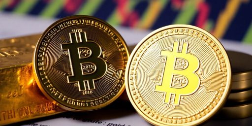 Gold bars with a bright Bitcoin coin in focus.